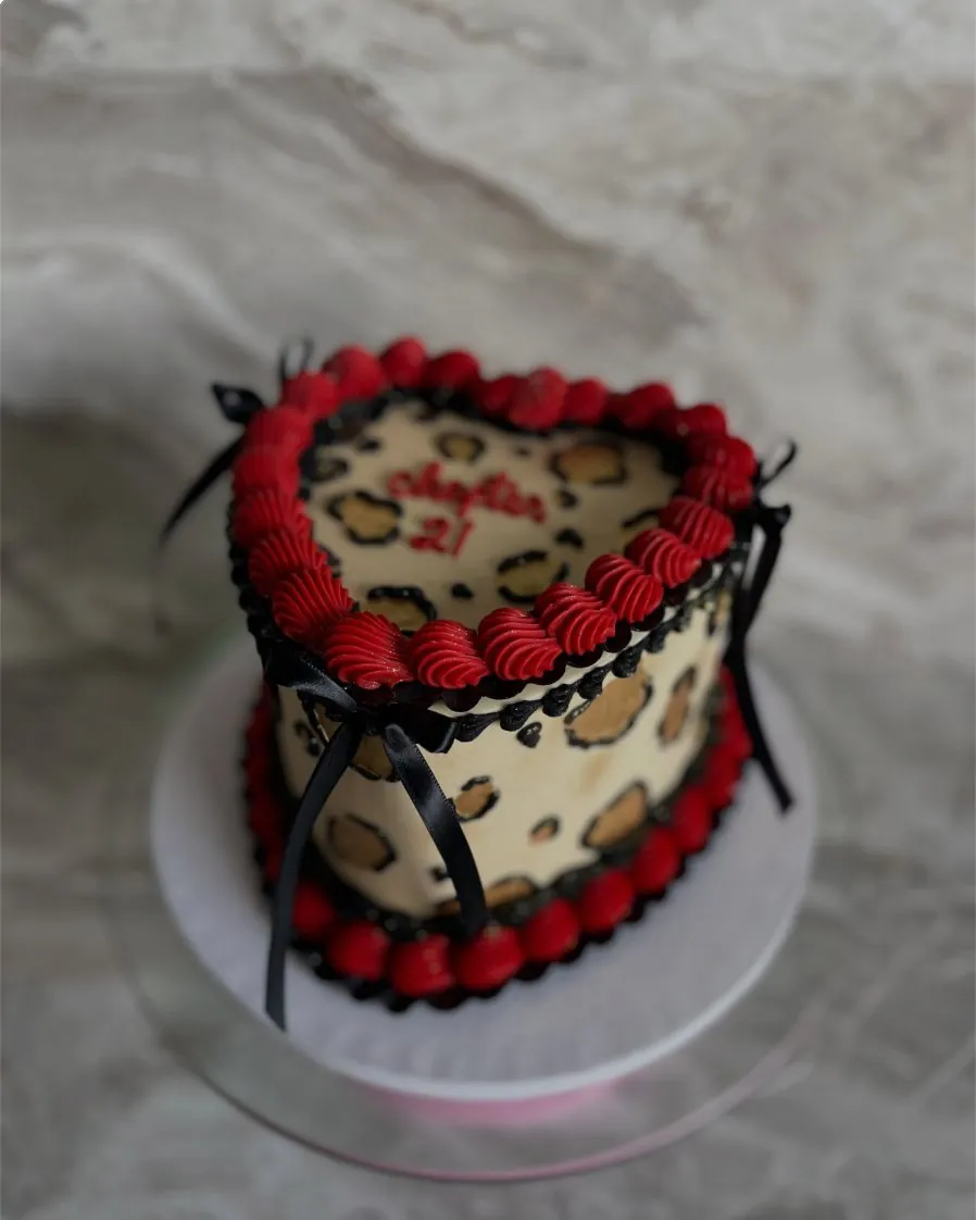 Leopard print heart cake with red piping and black ribbons